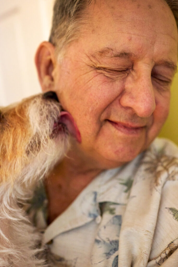 Dog licks older mans face