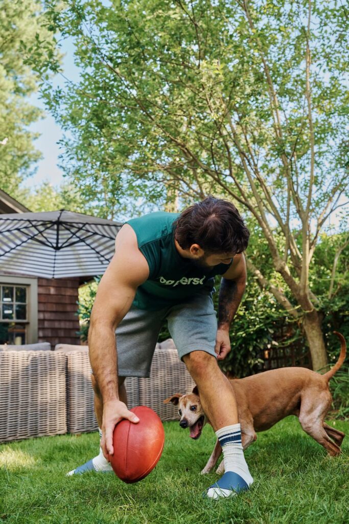 Cam Skattebo and Duke playing football in a backyard.